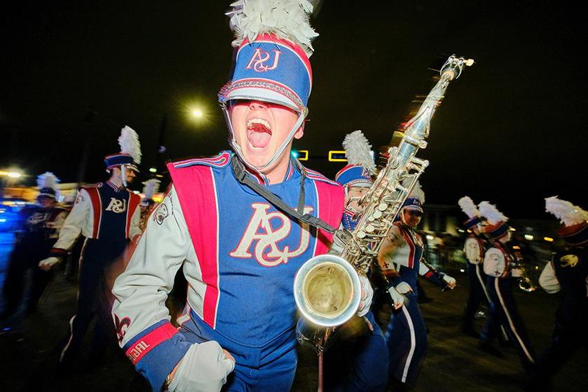 Jaguar Marching Band holding up his Saxophone while smiling